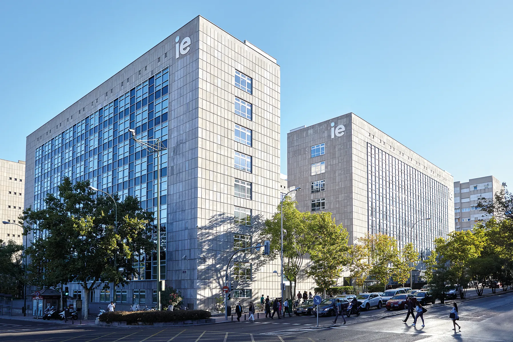 Fachada acristalada del IE Tower reflejando el cielo de Madrid
